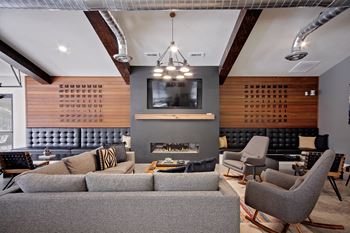 A modern living room with a grey sofa and a fireplace.